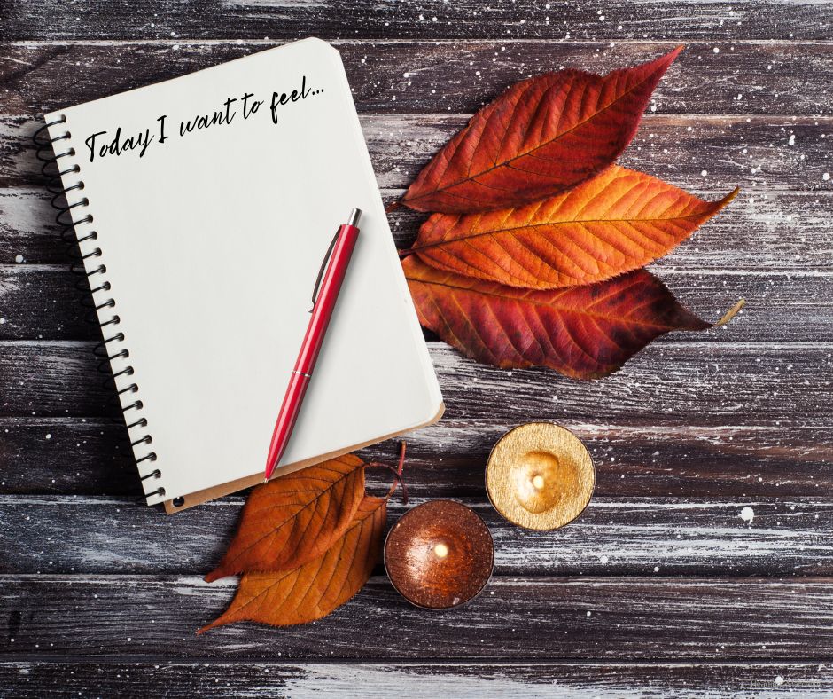 Fall-themed flat lay with journal prompt “Today I want to feel…”, red pen, candles, and autumn leaves on rustic wood—inviting mindful morning reflection.