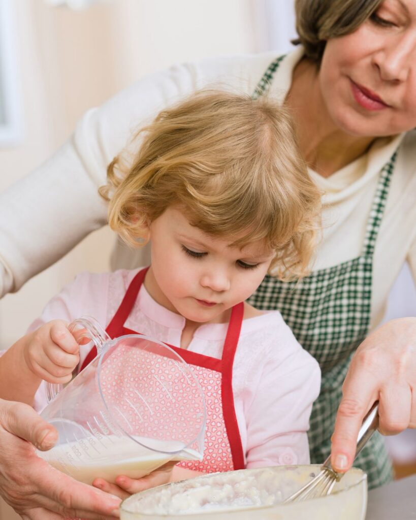 Grandmother and young granddaughter baking together in the kitchen, showing how a full life can still include meaningful family moments and time for what matters.